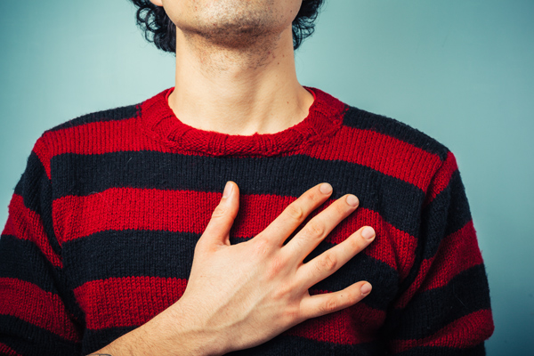Mann, im rot-schwarzen Pulli, mit Hand auf Herz © LoloStock/AdobeStock